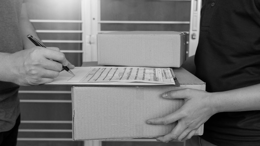 Delivery man in blue uniform handing parcel box for client signing checklist after confirm receiving package.